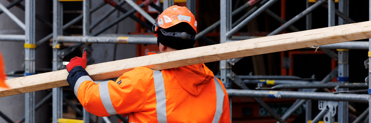 Håndværker på byggeplads der kan aflevere sit gamle arbejdstøj til genanvendelse